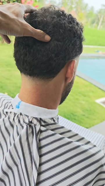 Close-up of a curly haircut with a clean tapered neckline
